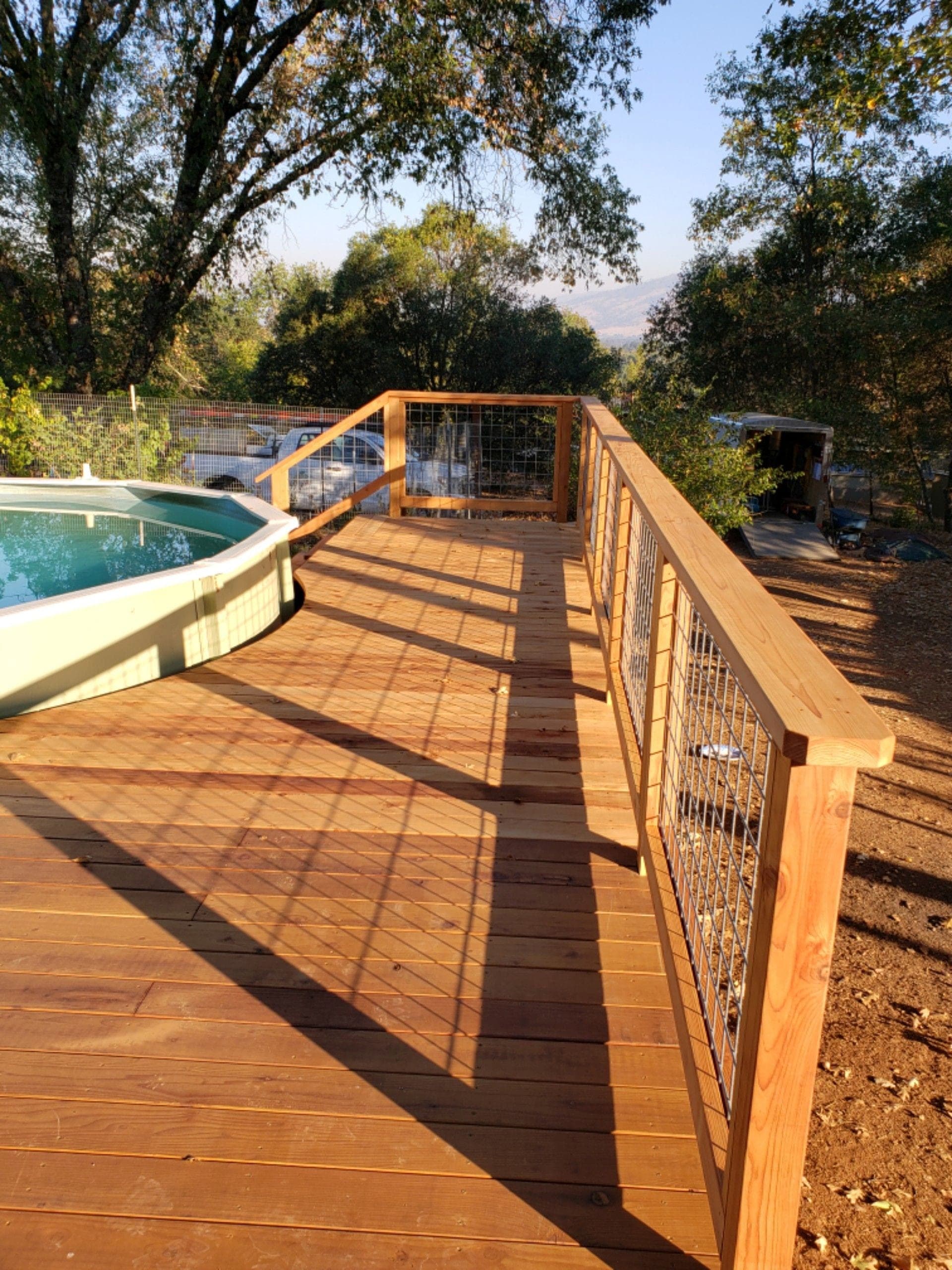 Poolside redwood deck with a hog-wire panel railing and mountain view, built by RLS Custom Carpentry in Lucerne, CA