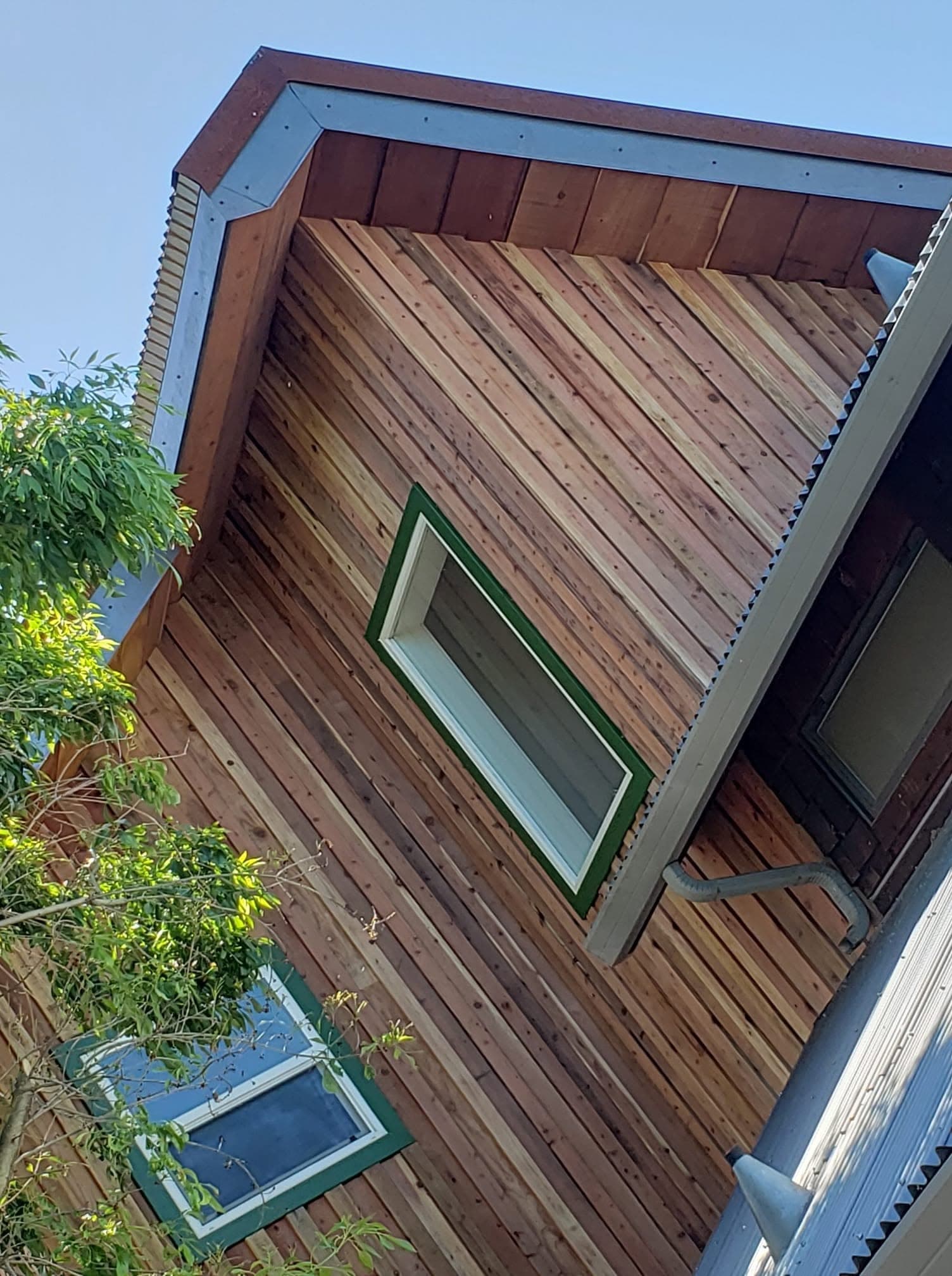 Vertical cedar tongue-and-groove wood siding with metal flashing detail and framed window on a gable end, custom carpentry by RLS Custom Carpentry in Mendocino County CA